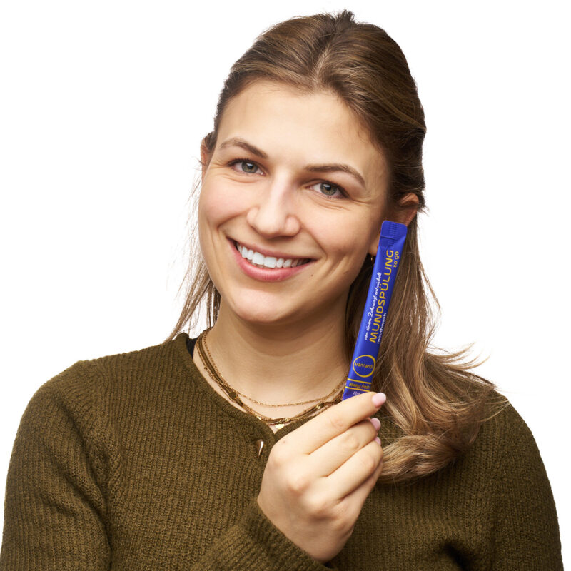 frau hält vannandi mundspülung vor kamera