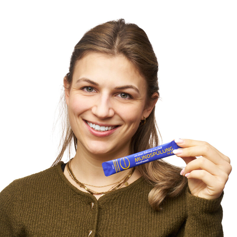 Frau hält vannandi mundspülung vor die kamera